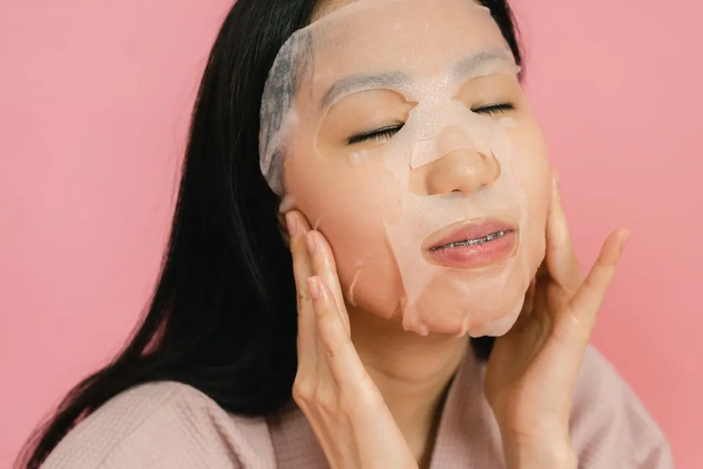 Đắp mặt nạ giấy trên nền hồng