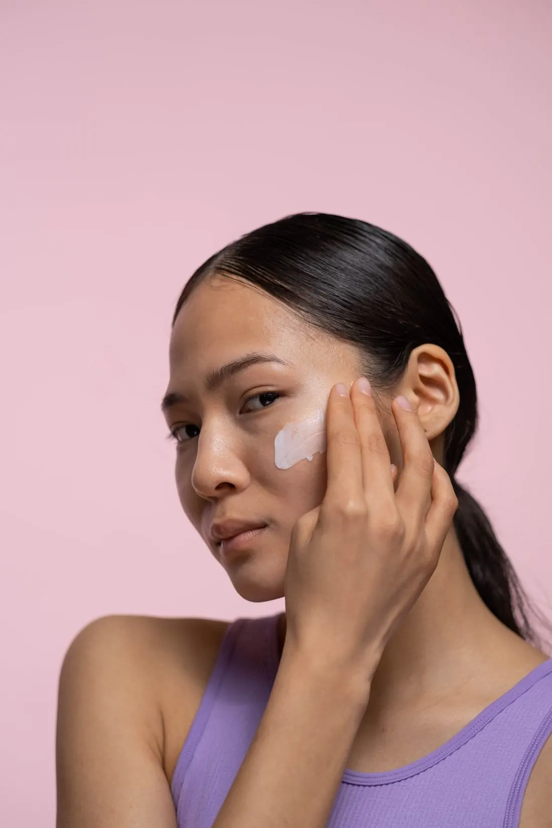 Thoa kem dưỡng lên gò má trên nền hồng